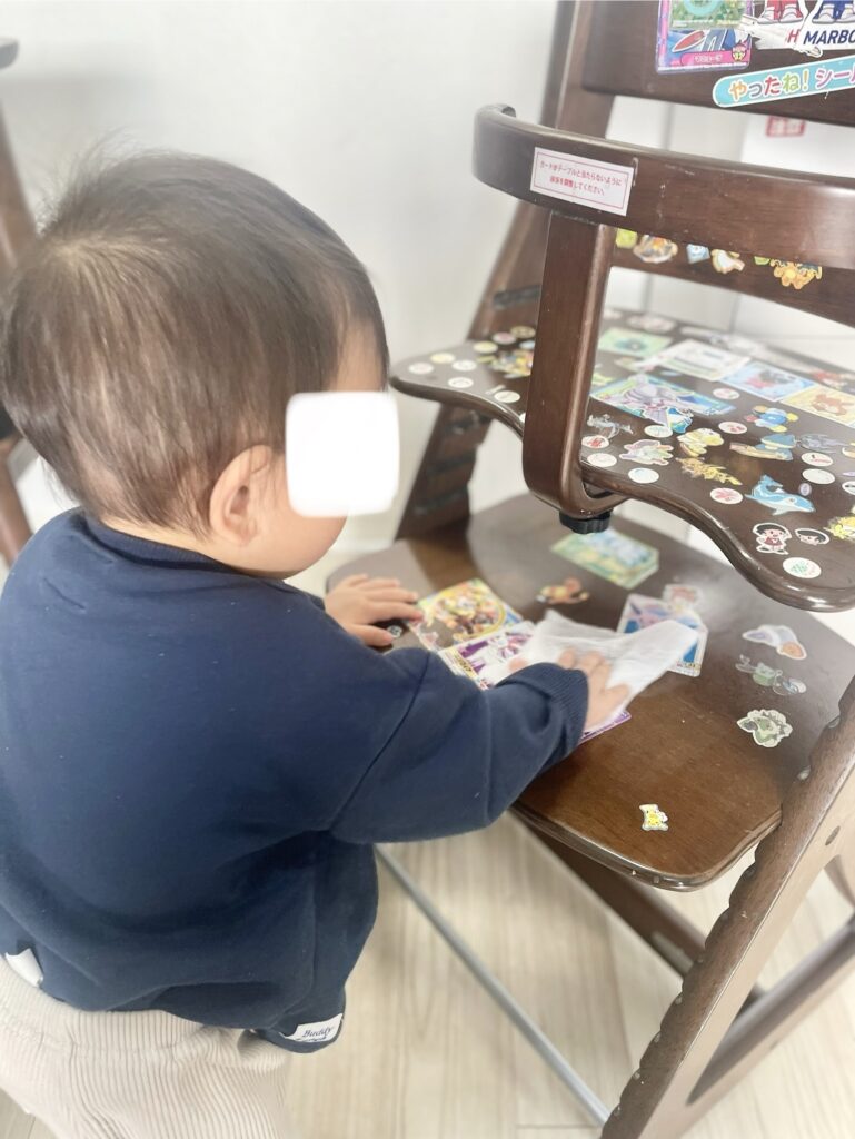 すくすくチェアスリムをシートで拭く真似をする1歳の子ども